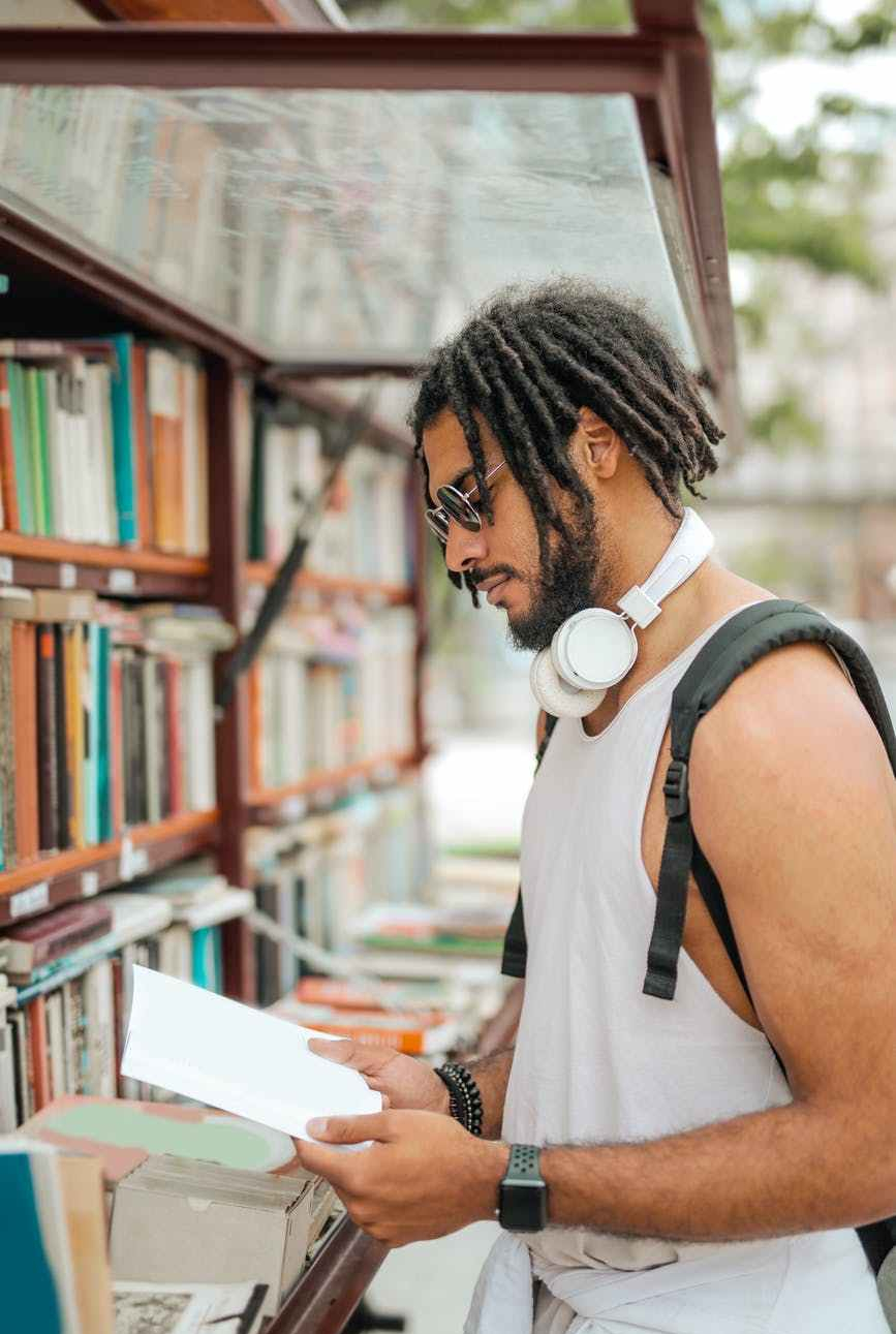 man with dreadlocks reading book, bookshop