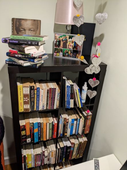 A full bookshelf, mostly titles in foreign languages and by Black authors.